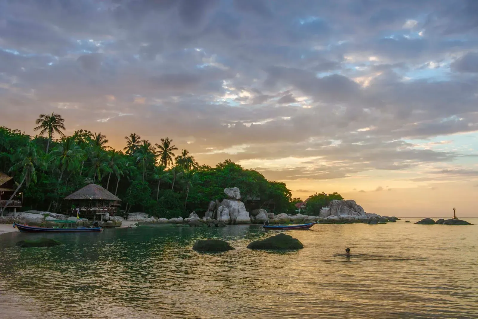 Rocky shoreline and calm water at Koh Tao beach near Koh Samui at sunset