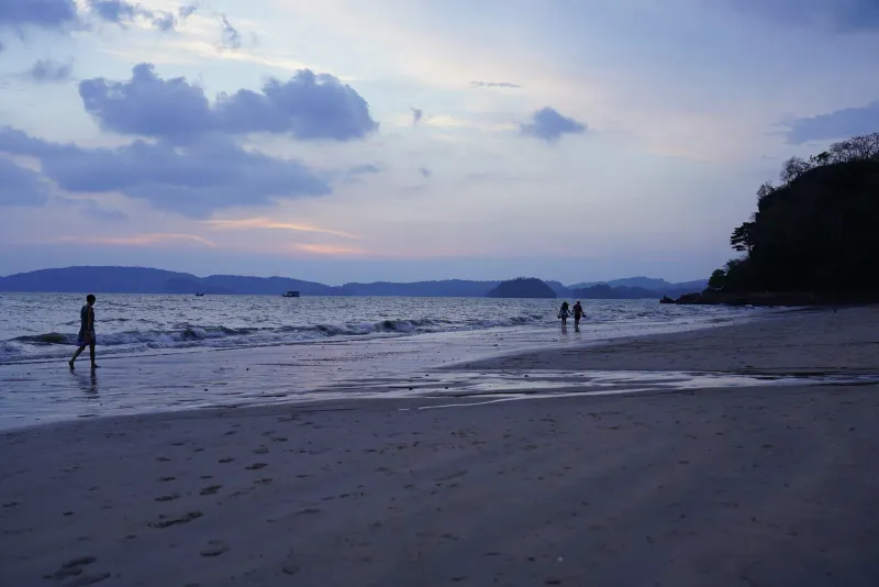 水平線に石灰岩の島々が見える、クラビのアオナン（Ao Nang）近くの夕暮れのビーチ