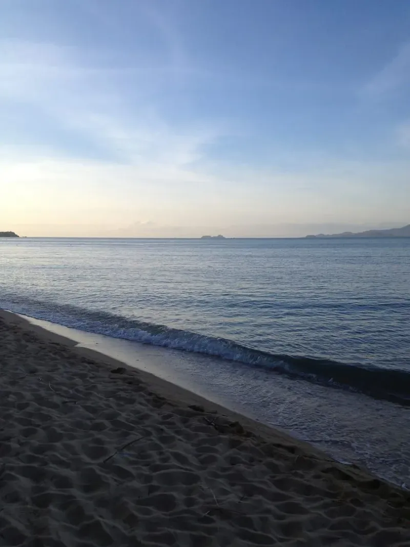 Calm dawn light on Maenam Beach, Koh Samui, with mountains across the water