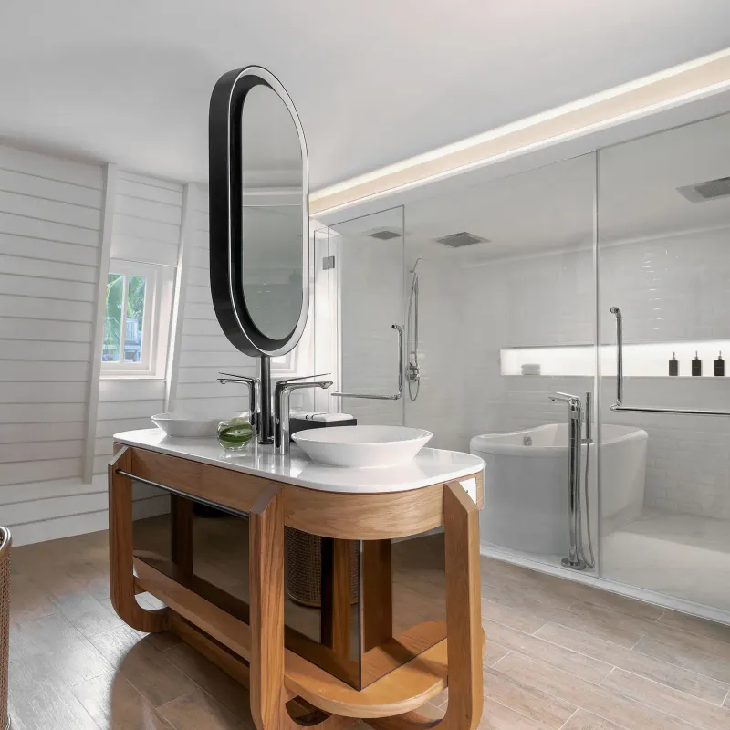 Bagno di una suite del Melia Koh Samui con due lavabi, specchio ovale, doccia di vetro e vasca freestanding