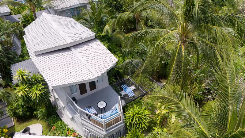 Veduta aerea della terrazza di una suite e di una zona relax con rete del Melia Koh Samui circondate da palme da cocco