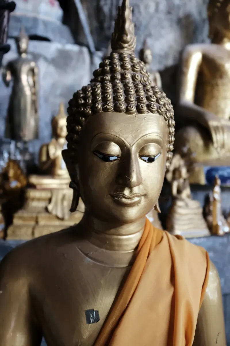 Nahaufnahme einer vergoldeten Buddha-Statue in einem Höhlenschrein