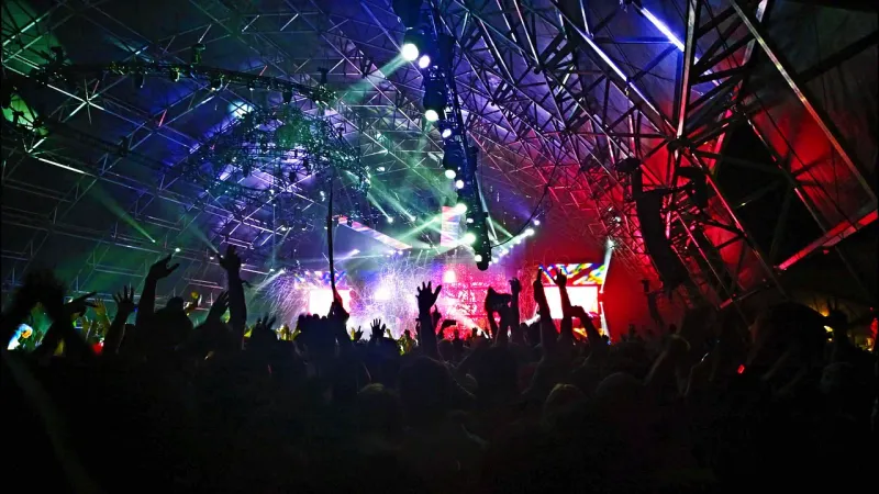 Colourful stage lights over a festival crowd