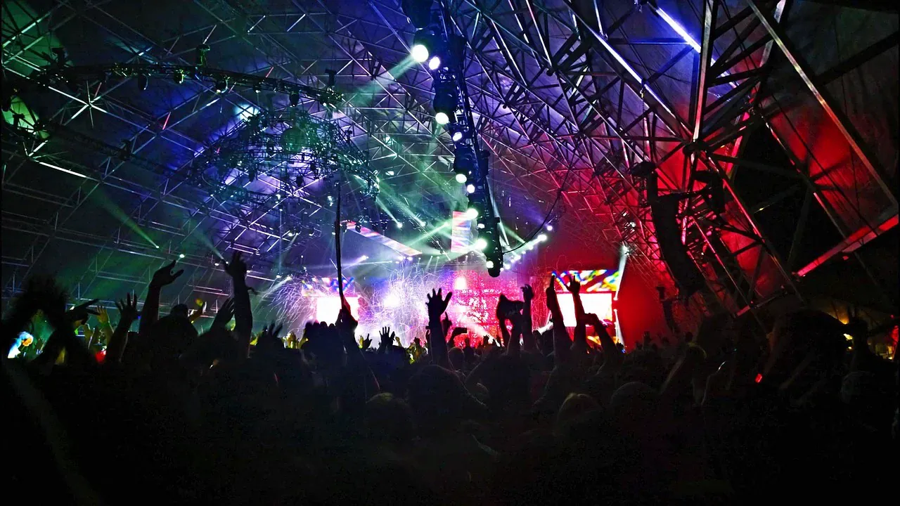 Colourful stage lights over a festival crowd