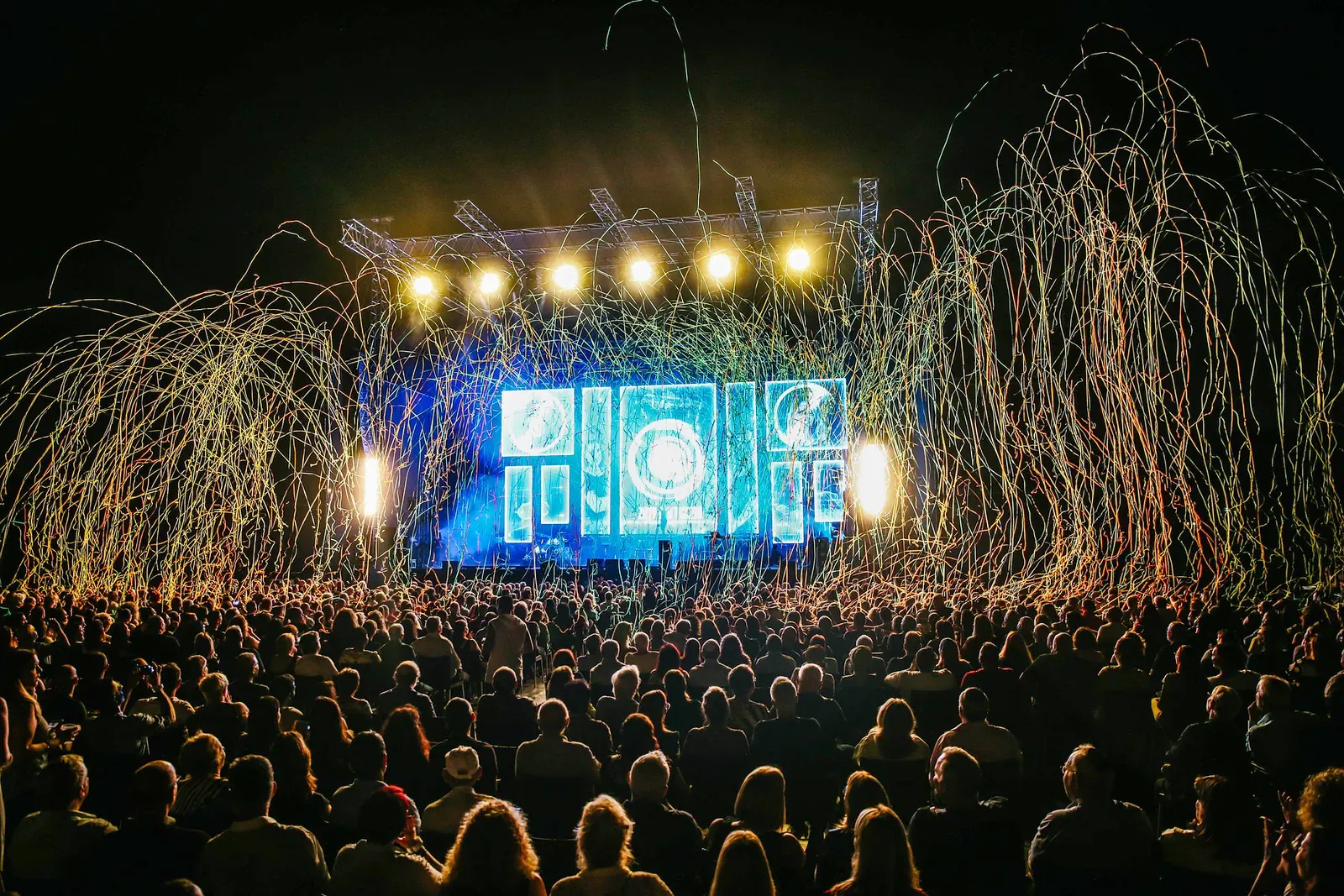 Stage with smoke and coloured lights above a crowd