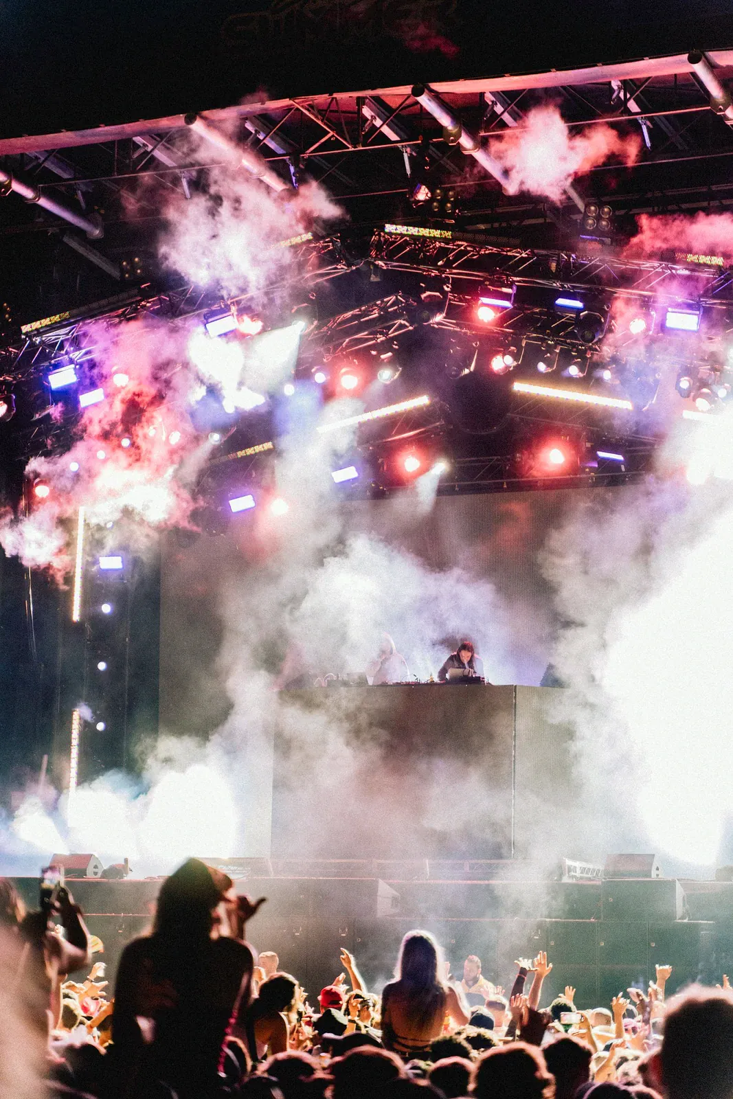 Stage with smoke and coloured lights above a crowd