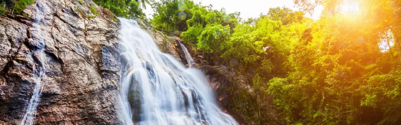 Na-Muang-Wasserfall in warmem Nachmittagslicht über die Felsen stürzend