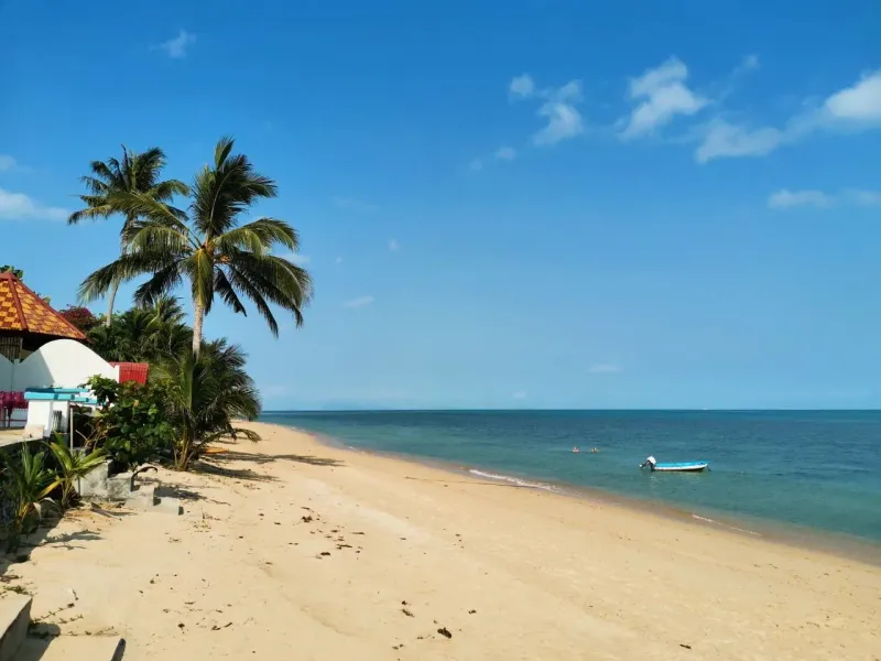 Ein einzelnes Boot vor einem ruhigen lokalen Strand