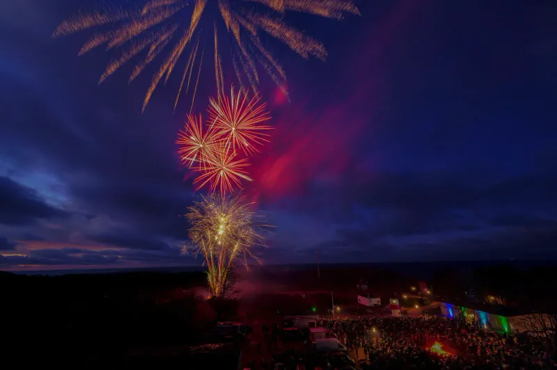 Red and gold fireworks over the sea at night