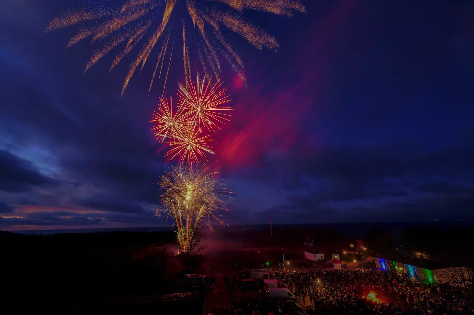 Red and gold fireworks over the sea at night