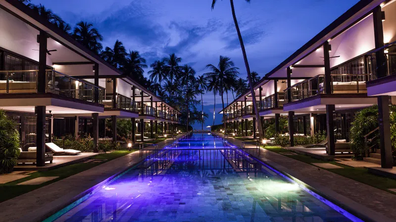 Aerial view of Nikki Beach Koh Samui's villas, pool and palm-lined beachfront at Lipa Noi