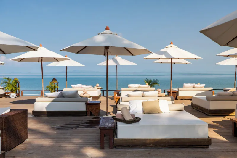 Nikki Beach Koh Samui's lap pool and guest suites lit up at dusk