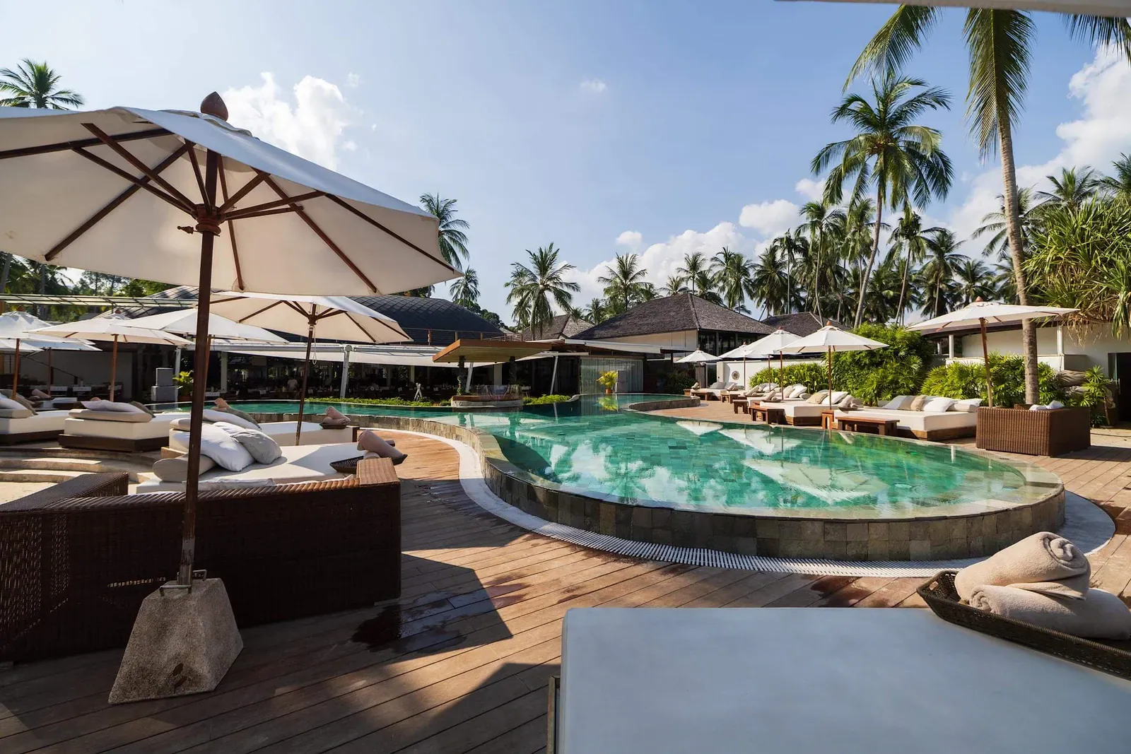 Sea-view daybeds and sun umbrellas at Nikki Beach Koh Samui's restaurant and beach club, as shown on the venue's own site