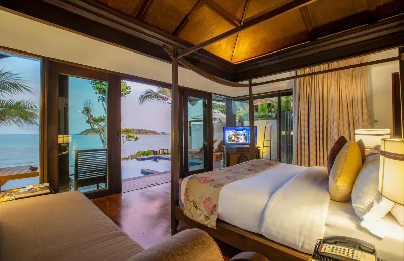 Lit à baldaquin dans une villa avec piscine du Nora Buri Resort, mer et piscine visibles à travers la vitre