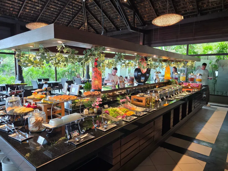 Comptoir du buffet du petit-déjeuner avec plats chauds et cuisiniers au Nora Buri Resort