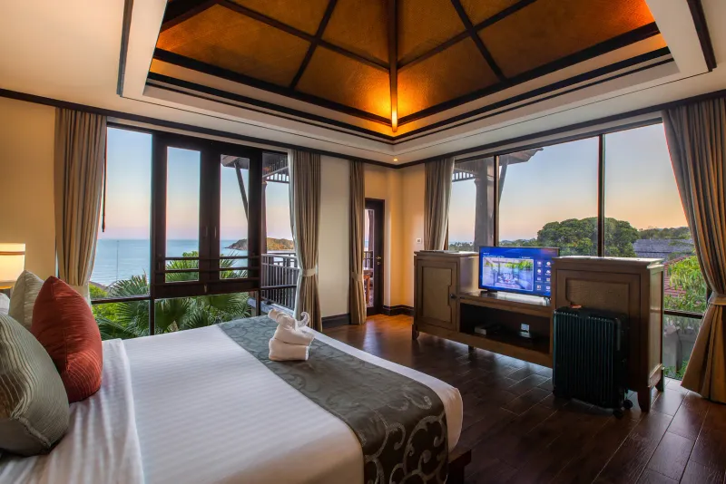 Chambre deluxe à flanc de colline avec vue sur la mer au Nora Buri Resort, grand lit, plafond en teck et baies vitrées donnant sur le balcon