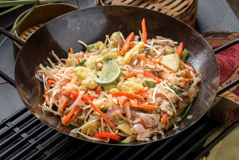 Noodles saltati con carote e lime in un wok dalla cucina dell'Outrigger Koh Samui