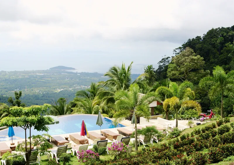 Aerial view of Paradise Park Farm's infinity pool and loungers with the Taling Ngam coastline far below