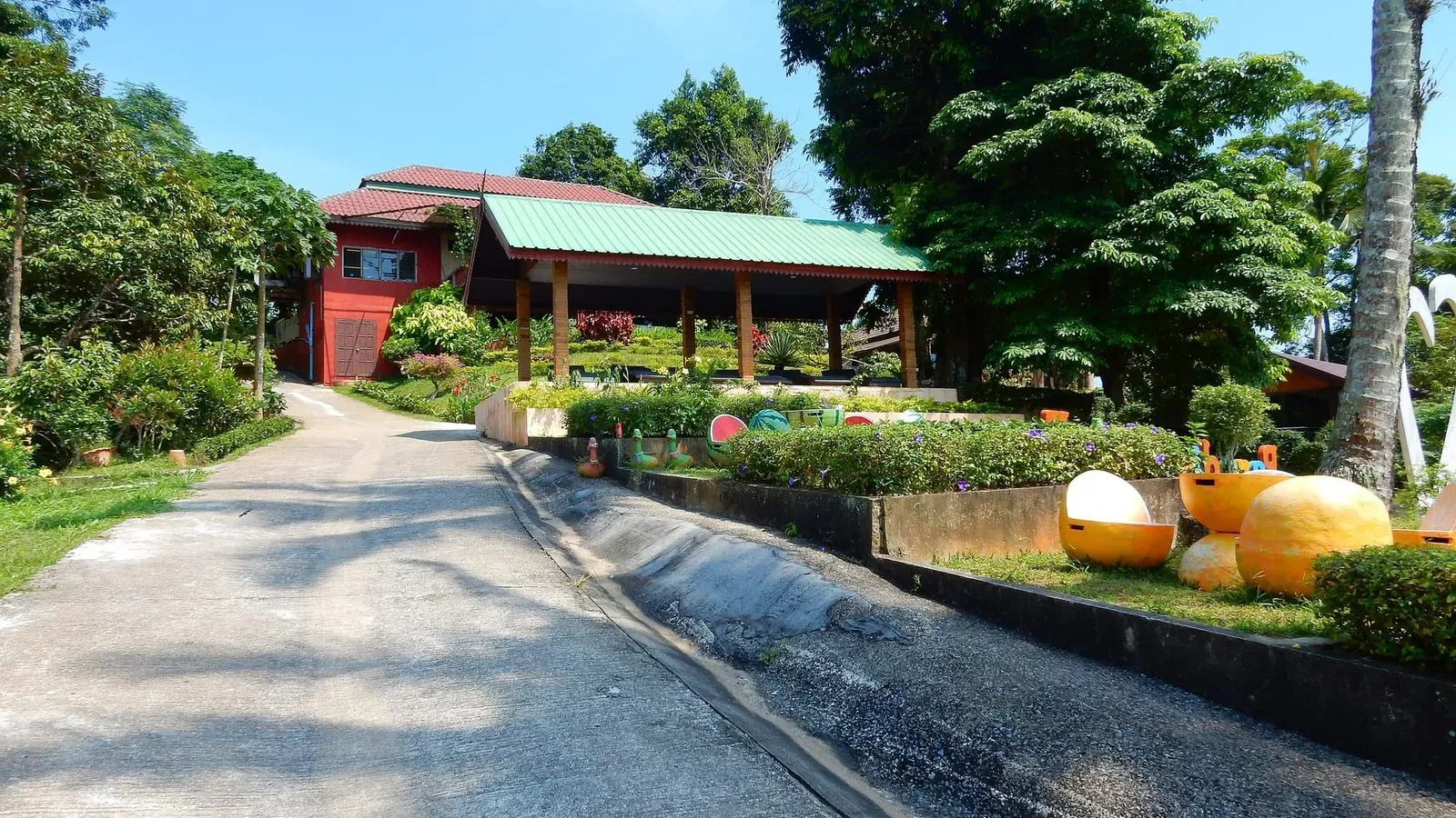 Red-painted entrance building and open-sided pavilion at Paradise Park Farm on Koh Samui's Khao Pom mountain