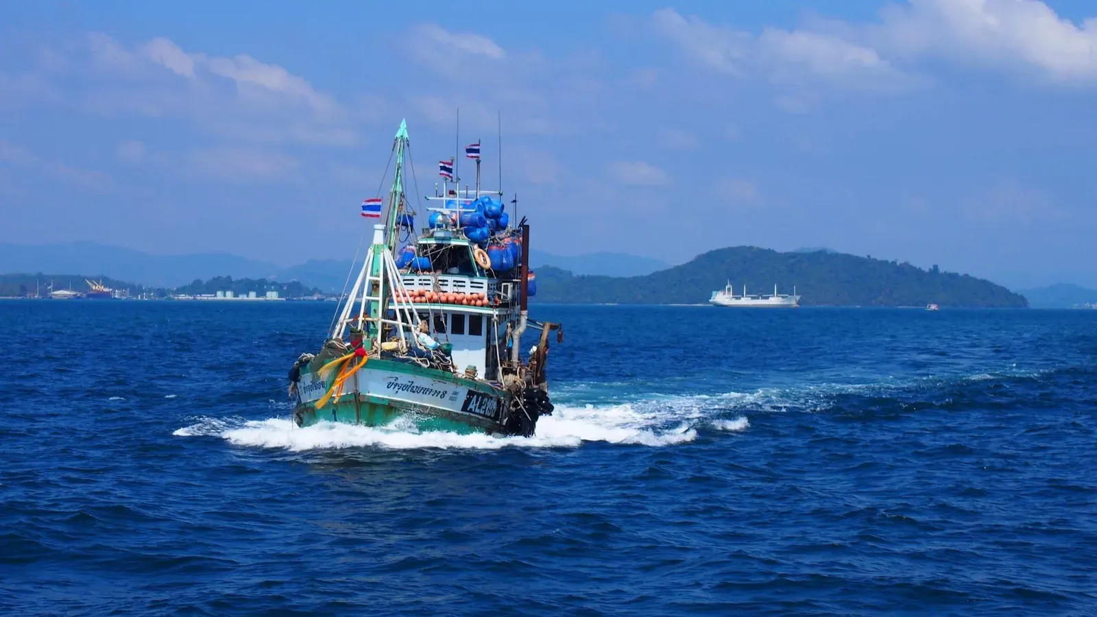 Colorful traditional fishing boat off the coast of Phuket in clear blue water