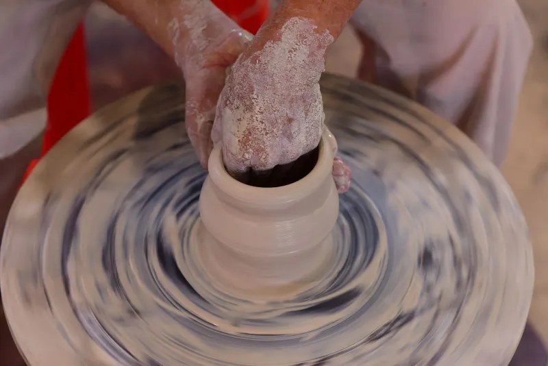 Close-up of hands shaping clay on a spinning pottery wheel