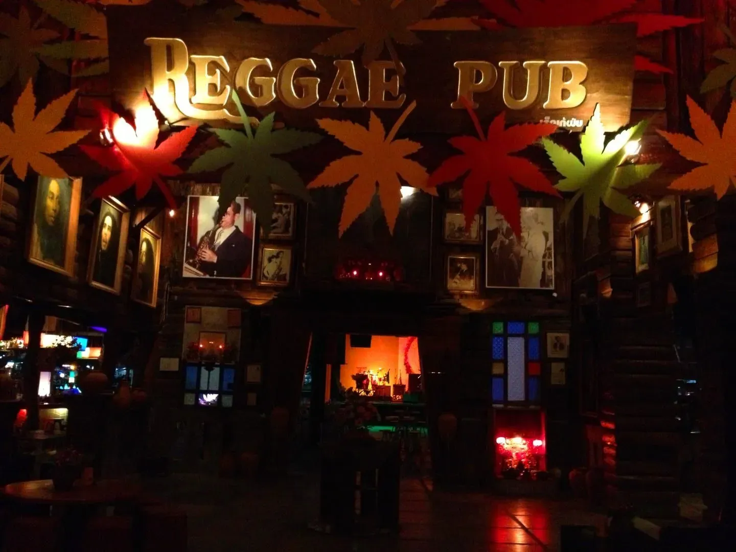 Reggae Pub entrance sign lit up with Bob Marley portraits and leaf decorations, Soi Reggae, Chaweng, Koh Samui