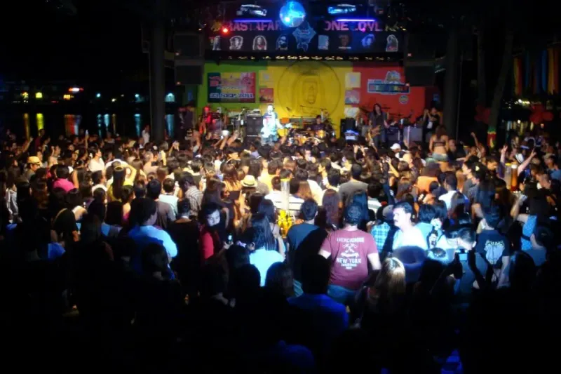 チャウエンのReggae Pubで、湖畔のステージで演奏するライブバンドを見る観客