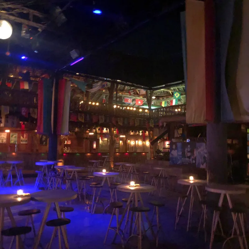 Reggae Pub's interior with international flags hanging from the ceiling and candlelit tables