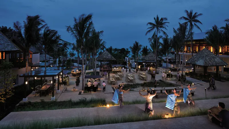 Patio de dîner au crépuscule avec stands de nourriture et spectacle de danse thaïe entre les palmiers