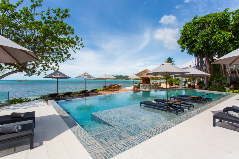 Piscina a sfioro del Rocky's Boutique Resort con lettini e ombrelloni sopra il Golfo di Thailandia