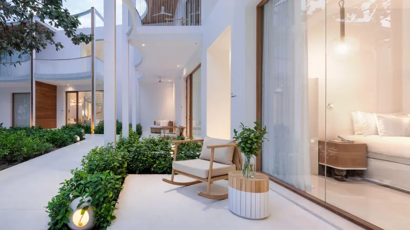 Terrasse d'une villa avec piscine dans le jardin du SALA Samui Chaweng, avec transats, plantes et chambre vitrée