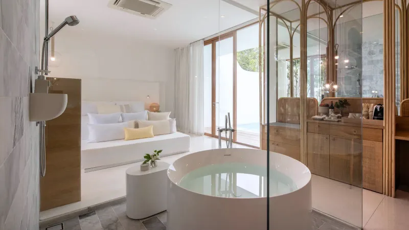 Salle de bains d'une villa avec piscine dans le jardin du SALA Samui Chaweng, baignoire ronde îlot près d'une paroi de verre