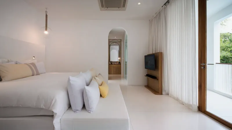 Chambre d'une suite familiale à deux chambres dans le jardin du SALA Samui Chaweng, grand lit, linge blanc et télévision murale
