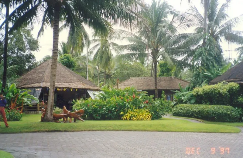 A covered walkway at Samui Airport's terminal, the airport visible from The Cocoon's hillside above