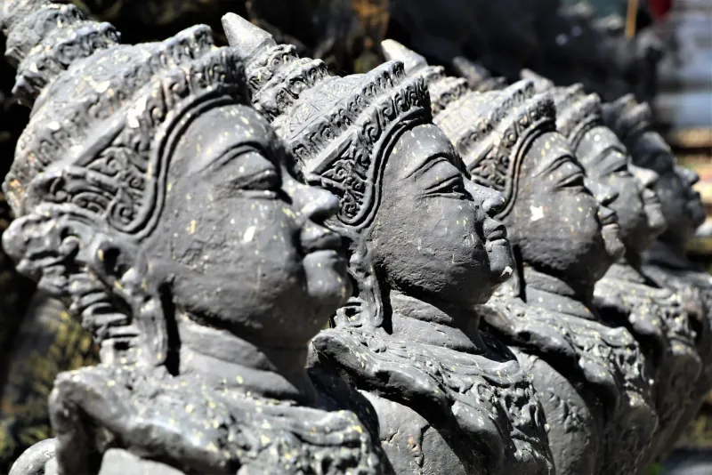Roadside shrine statues near a Koh Samui taxi stand, a common sight along transport routes
