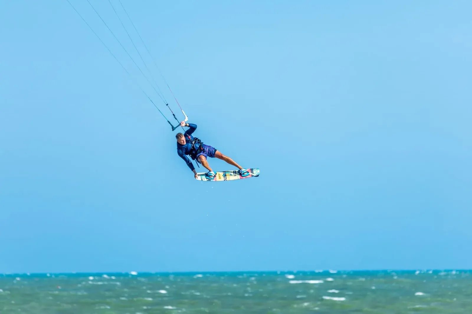 Kitesurfer launching an aerial trick over open water off Koh Samui's south coast during the wind season