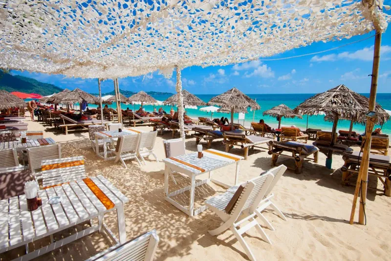 Beach tables under parasols and cloth shade on Koh Samui