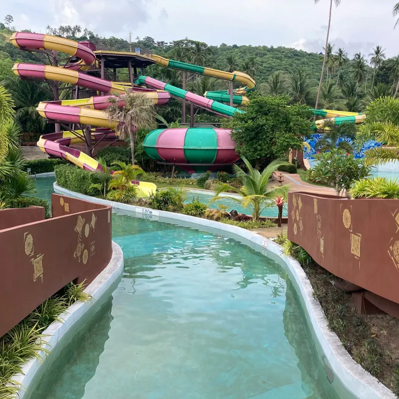 The lazy river channel winding past the slide tower and pools at Samui Water Park, Maenam