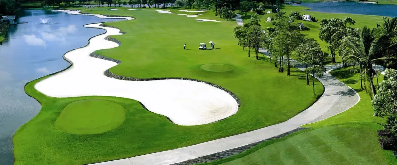 A fairway at Santiburi Samui Country Club with a bunker and rolling hills in the distance