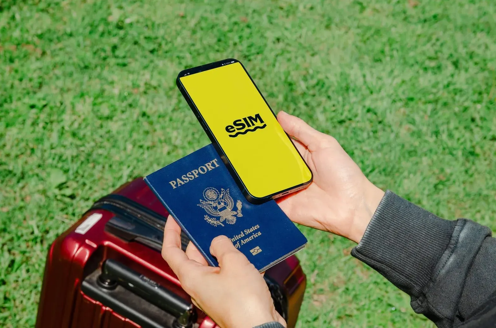 Traveler holding a smartphone with an eSIM screen next to a passport and luggage before a Thailand trip