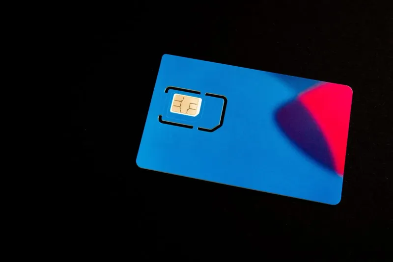 Blue Thailand tourist SIM card on a dark background with colorful accents