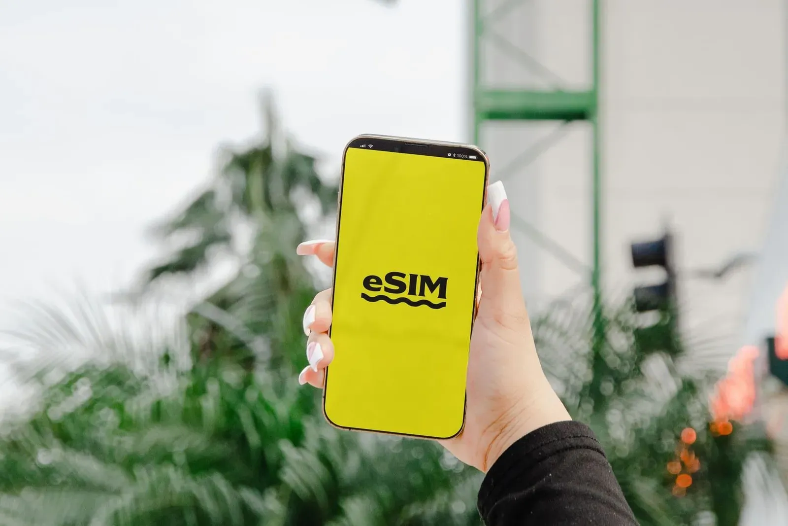 Hand holding a mobile phone displaying an eSIM setup screen outdoors on Koh Samui Thailand