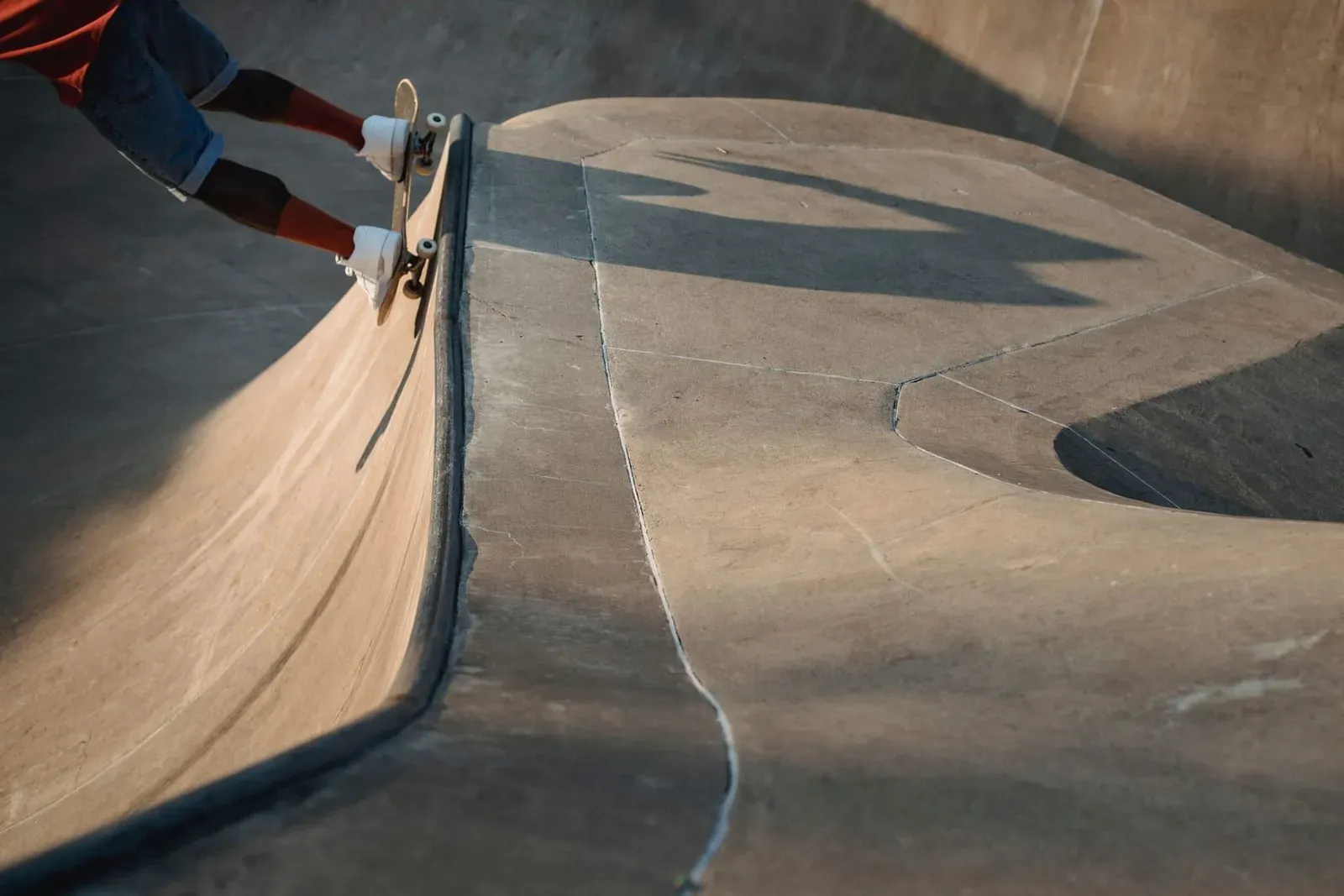 Skater riding a ramp and performing a trick at a concrete skatepark