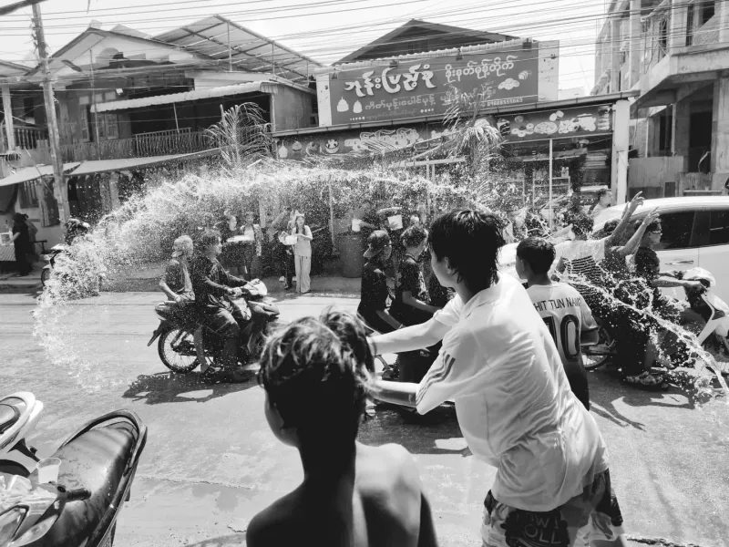 Crowds celebrating a traditional water-throwing festival in the streets, similar in spirit to Songkran