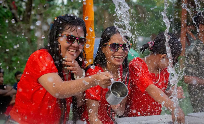 Festival crowd splashing water in the street, the same water-throwing tradition seen at Songkran