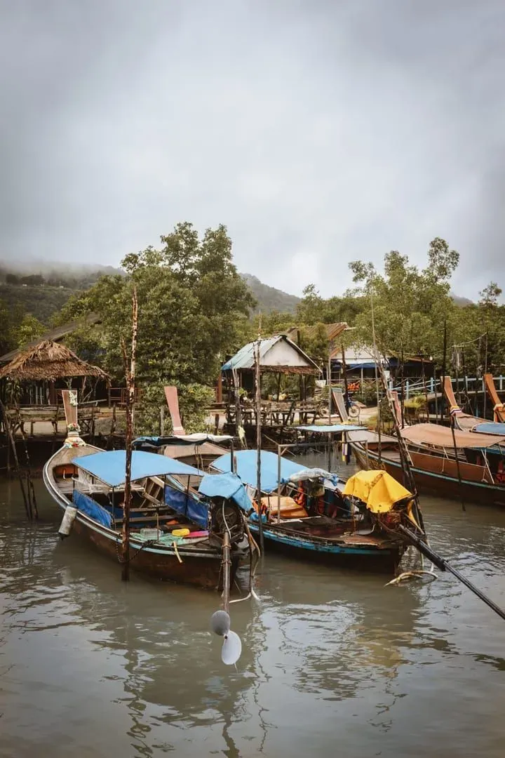 Traditional longtail boats moored at a Surat Thani dock near the Donsak ferry route