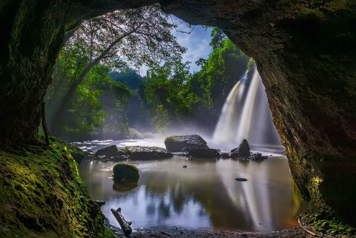 Dschungelwasserfall, gerahmt von einer höhlenartigen Felsöffnung