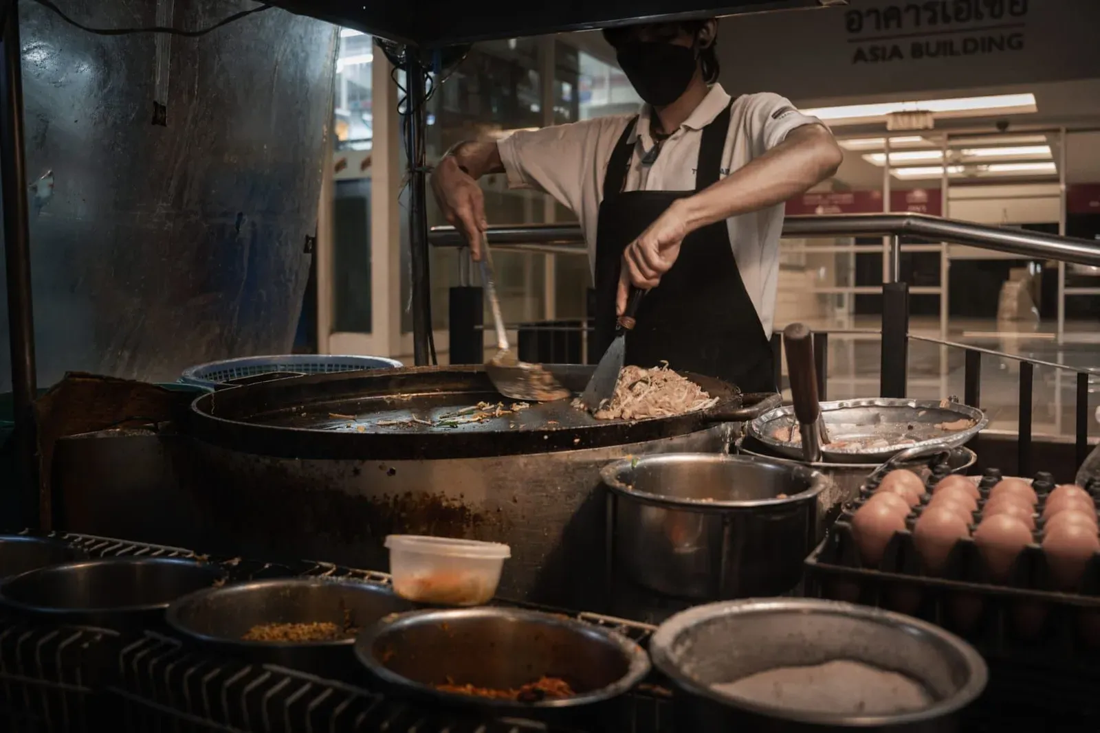 Chef cooking Thai dishes over an open flame, the hands-on style used in Koh Samui classes