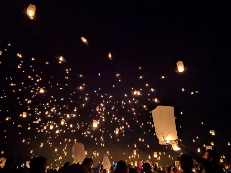 Floating lanterns illuminating the night sky during a vibrant festival, capturing Koh Samui's events calendar atmosphere