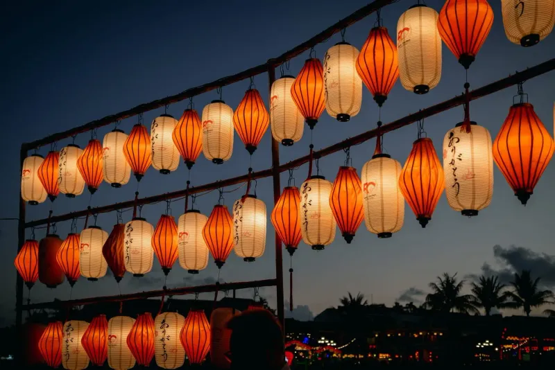 Orange and white lanterns hanging outdoors at twilight, matching the mood of Koh Samui's Chinese New Year shrines